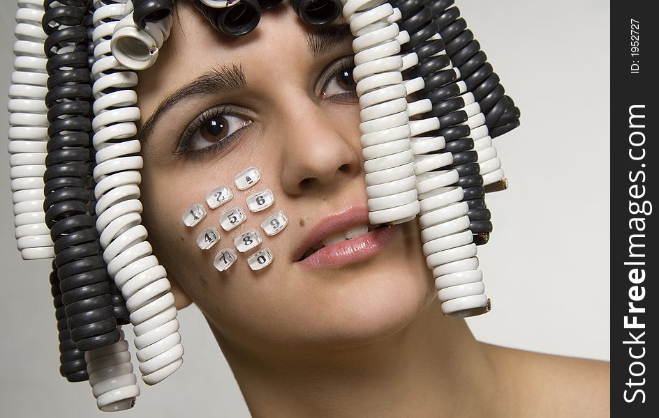 Beautiful young girl with telephone cables and buttons with numbers. Beautiful young girl with telephone cables and buttons with numbers