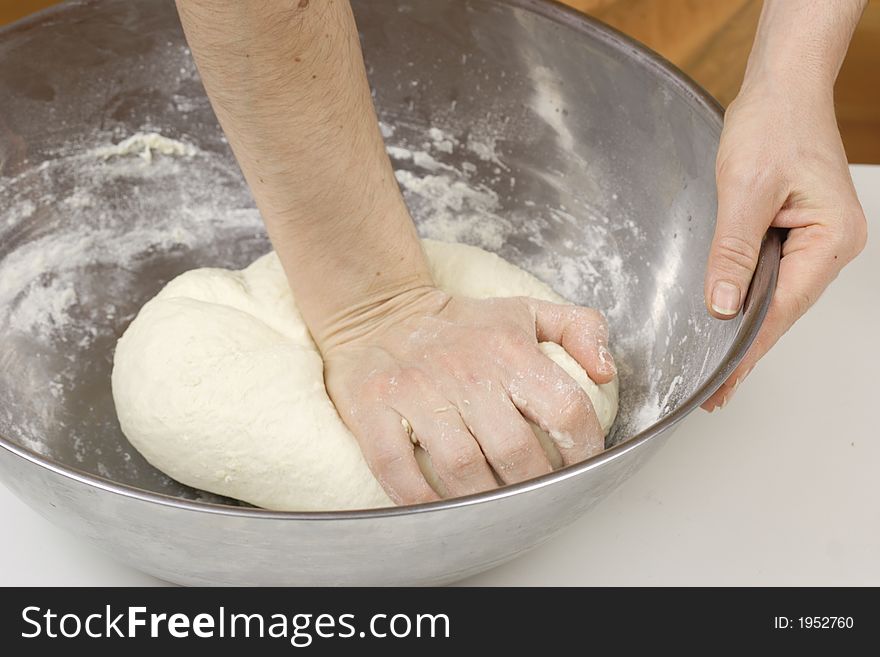 Woman's hands are kneading the dough