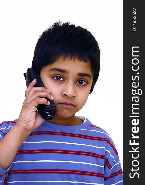 A kid speaking to some one over the phone. A kid speaking to some one over the phone
