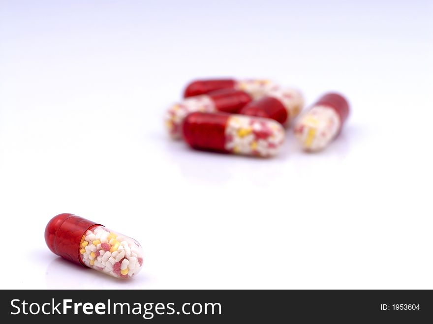 One focused capsule in front of a bunch of other capsules. One focused capsule in front of a bunch of other capsules