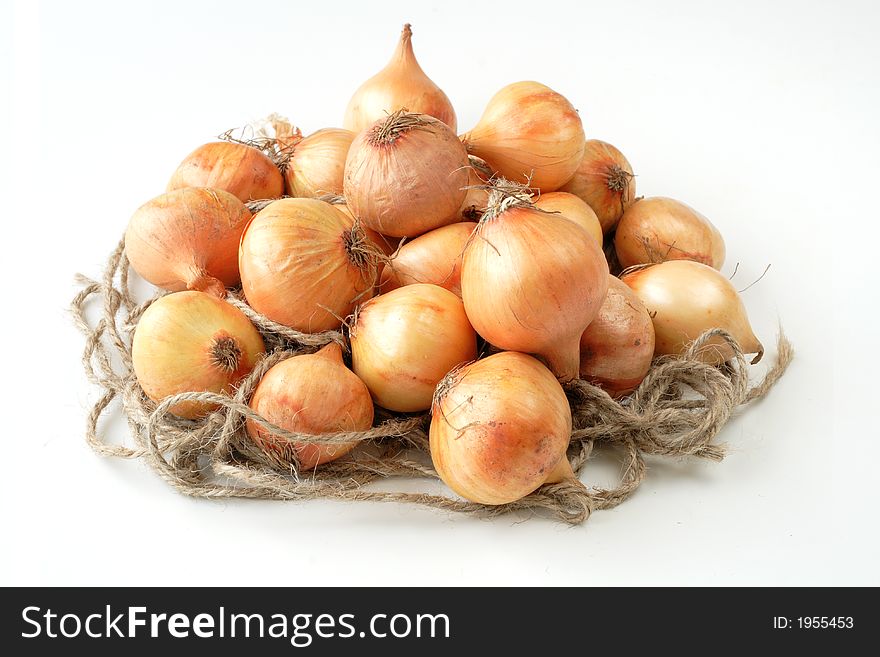 British baby onions on rope nest with white background