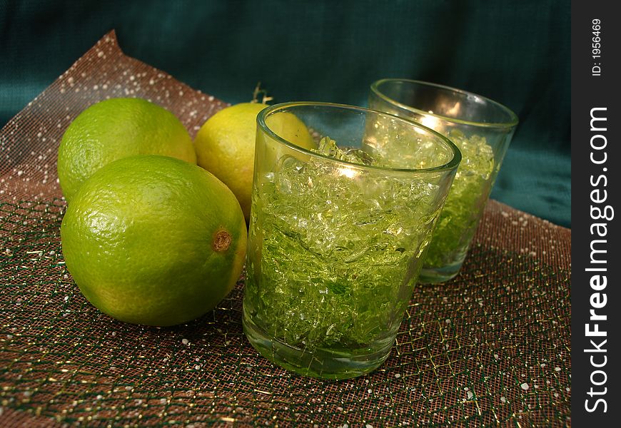 Green limes with candles on background