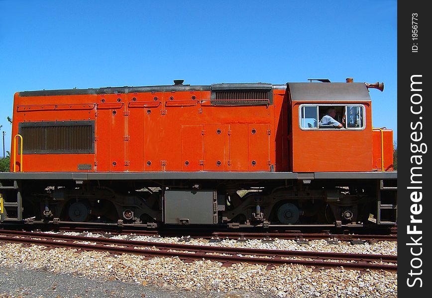 Bright orange train transporting it's passengers. Bright orange train transporting it's passengers