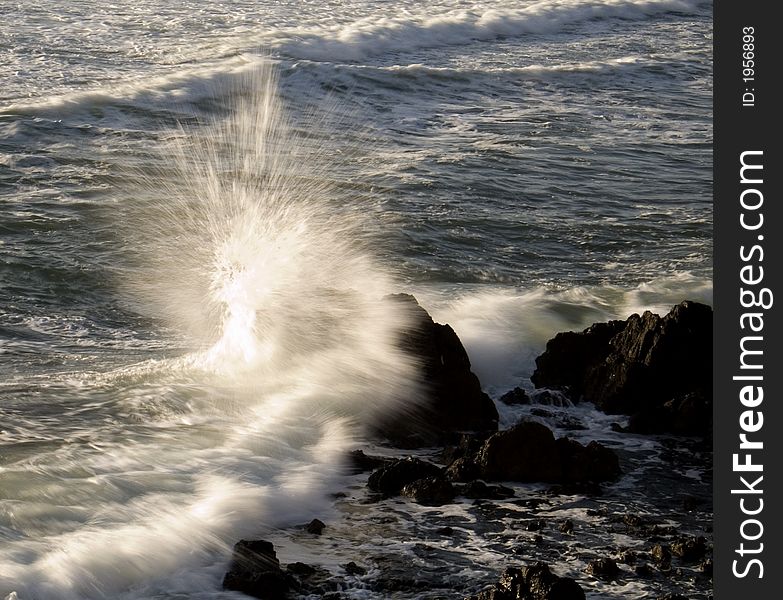 Large wave hitting rock with spray. Large wave hitting rock with spray