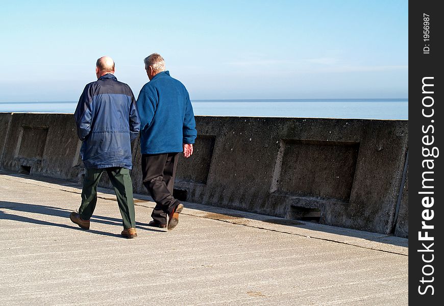 Two walkers on the sea front. Two walkers on the sea front