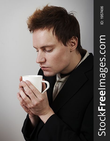 Businessman warming up with coffee cup after a cold day. Businessman warming up with coffee cup after a cold day