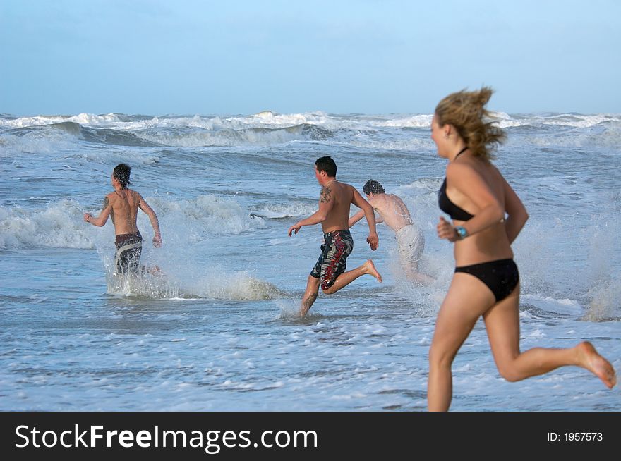 People running into the ocean. People running into the ocean