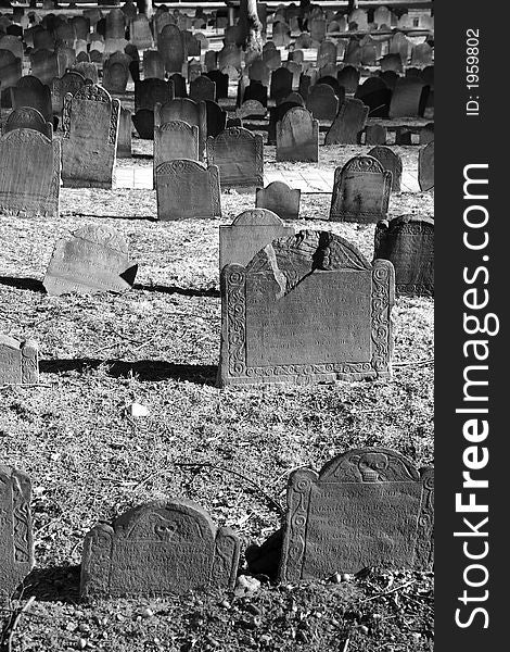 Ancient grave stones in black and white in bright sun light on a beautiful winter's day, portrait. Ancient grave stones in black and white in bright sun light on a beautiful winter's day, portrait