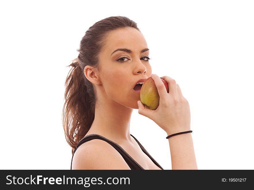 A young female dressed in black gym clothes eating an apple on isloted white background. A young female dressed in black gym clothes eating an apple on isloted white background