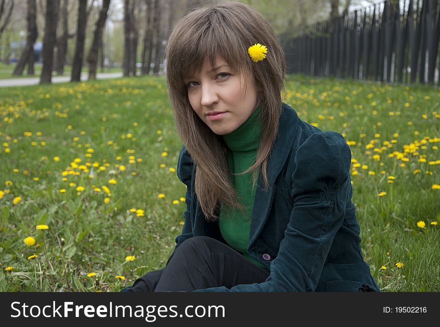 Young girl in a park sitting on grass. Young girl in a park sitting on grass