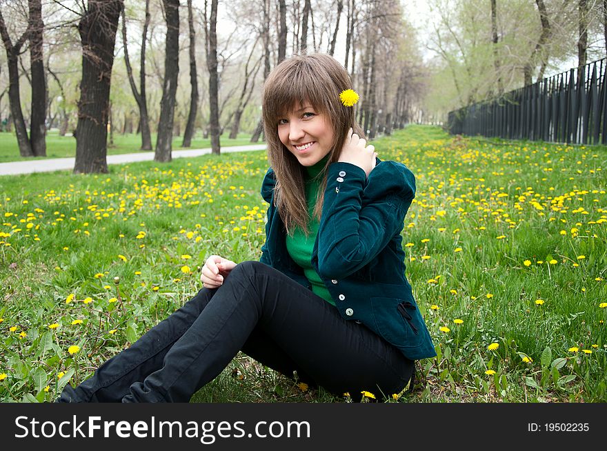 Young girl in a park sitting on grass. Young girl in a park sitting on grass
