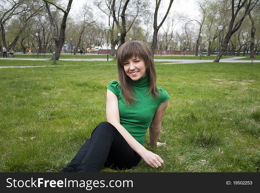Young girl in a park sitting on grass. Young girl in a park sitting on grass
