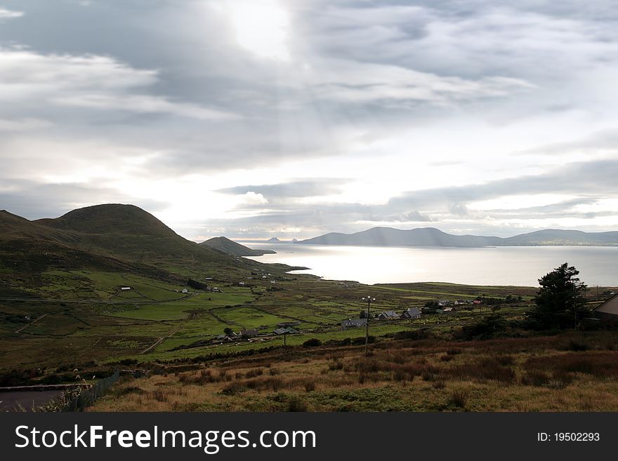 Kerry scenic view of the Skellig rocks in ireland with mountains against a beautiful blue cloudy sky. Kerry scenic view of the Skellig rocks in ireland with mountains against a beautiful blue cloudy sky