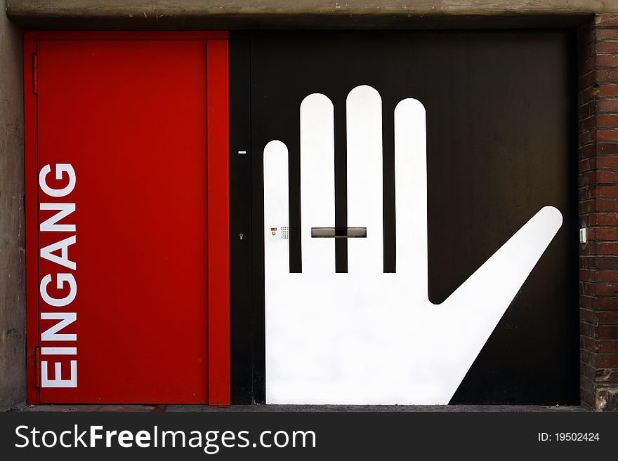 Red front door with white lettering and Hand