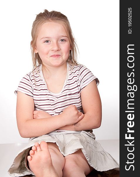 A photograph of a young girl with her arms crossed sitting on a desk trying not to smile. A photograph of a young girl with her arms crossed sitting on a desk trying not to smile.