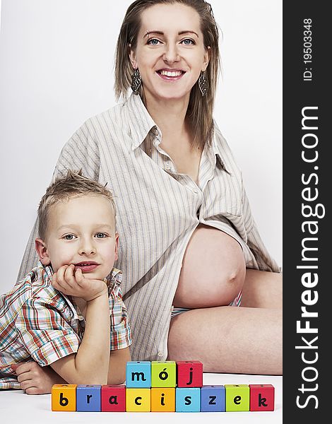 Pregnant mum and her son with colorful wooden blocks. Pregnant mum and her son with colorful wooden blocks