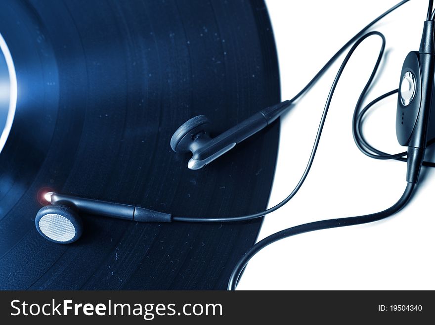 Photo of a vinyl record with earphones on white background