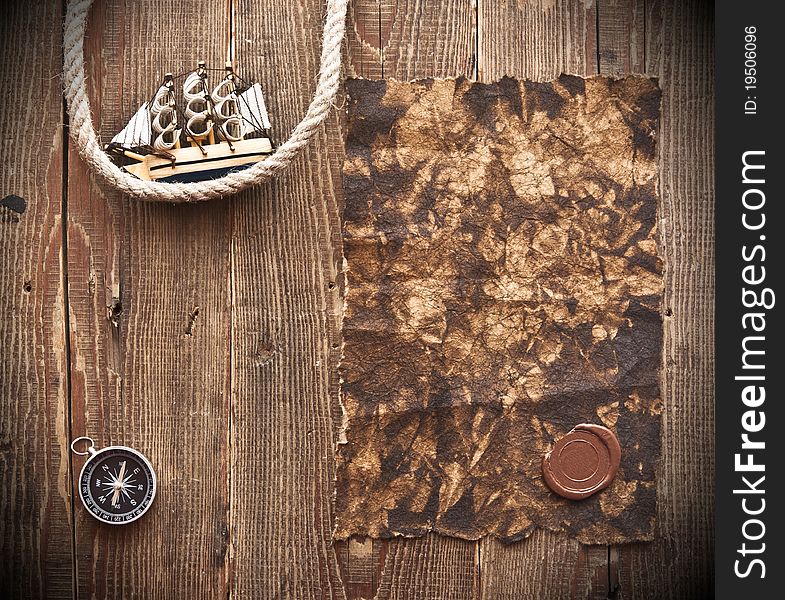 Old paper, rope and model classic boat on wood background