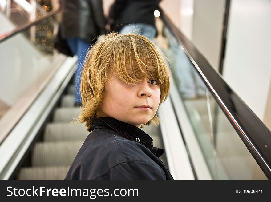 Child is smiling self confident on a stairway in a shopping mall. Child is smiling self confident on a stairway in a shopping mall