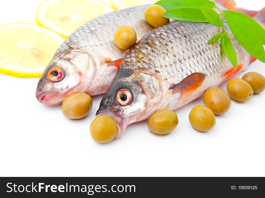 Cooking two fish redeyes with olives, isolated on a white background. Cooking two fish redeyes with olives, isolated on a white background