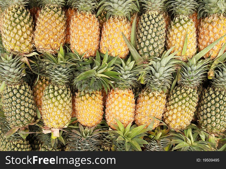 Pile of pineapples at a market stall.