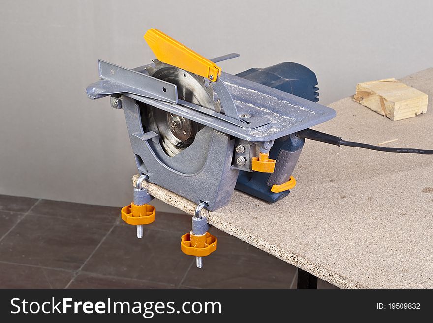 Close-up of a construction worker's hand and power tool while planing a piece of wood trim for a project. Close-up of a construction worker's hand and power tool while planing a piece of wood trim for a project.