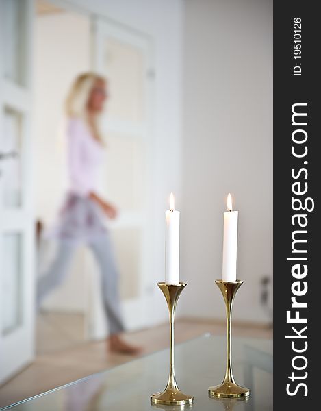 Woman passes through the living room which is illuminated by candle ligts. Woman passes through the living room which is illuminated by candle ligts.