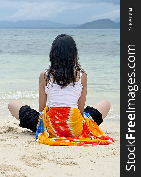 Young pretty girl rest at beach with colorful sarong