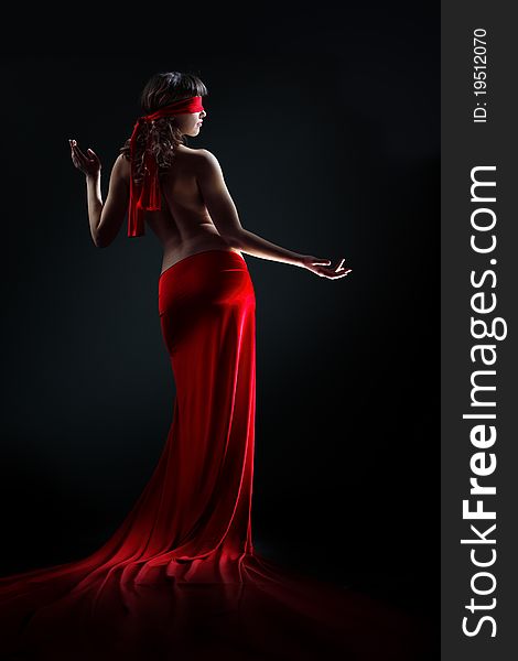 The girl in a red dress against a dark background
