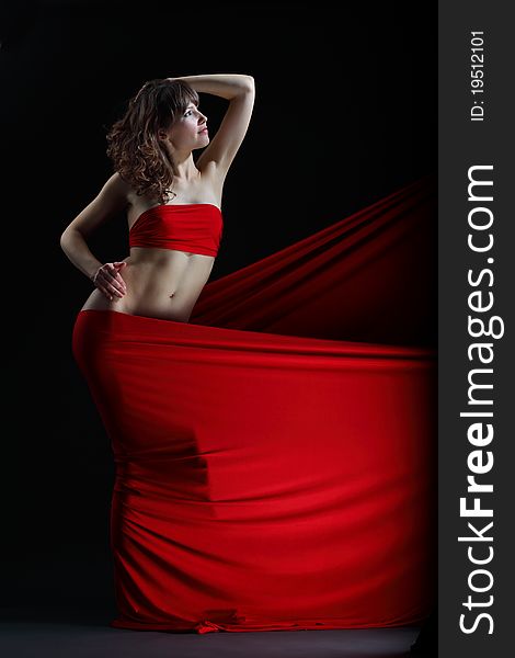 The girl in a red dress against a dark background