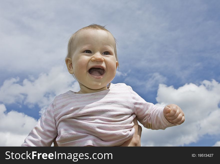 Holding 10 months old baby - cloudy sky background. Holding 10 months old baby - cloudy sky background