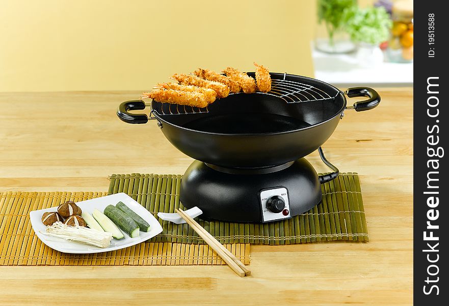 Fried shrimps tempura with electric pan an image isolated in the kitchen interior