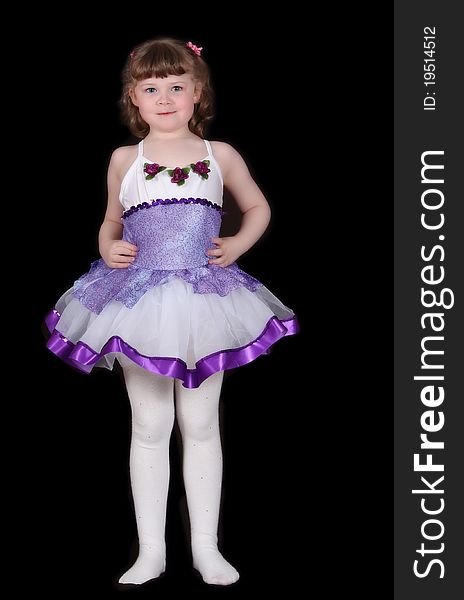 Adorable little girl standing proudly in her ballet outfit. Isolated on black. Adorable little girl standing proudly in her ballet outfit. Isolated on black