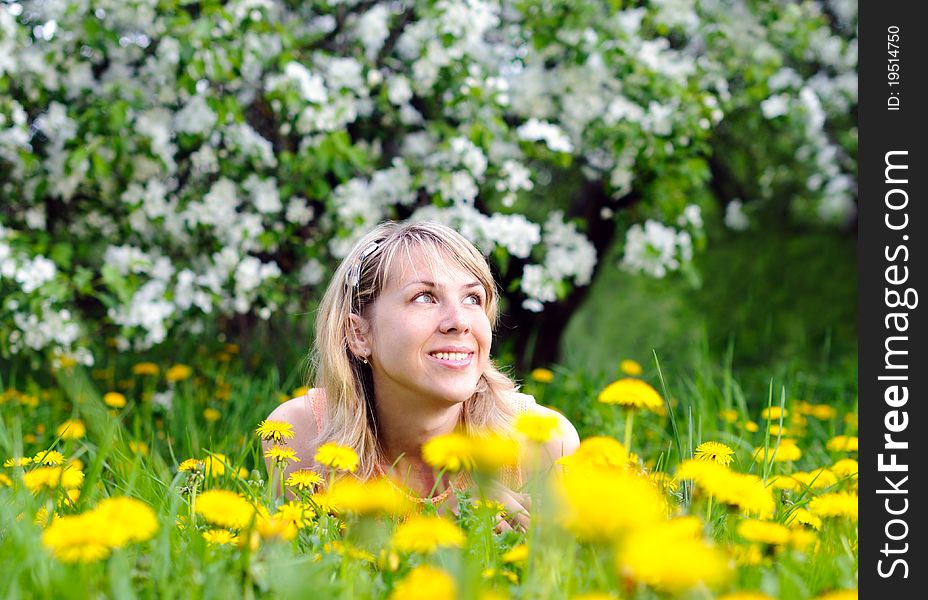 Young woman on the grass with yellow flowers