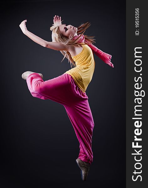 Full-length portrait of a woman dancing on a dark studio background. Full-length portrait of a woman dancing on a dark studio background
