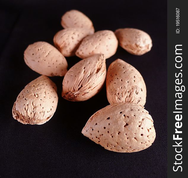 Brown Almonds lying on on a black background. Brown Almonds lying on on a black background