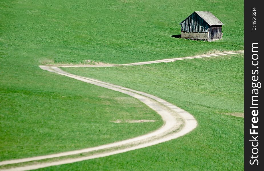 Crooked Road in the Meadow with a small hut. Crooked Road in the Meadow with a small hut