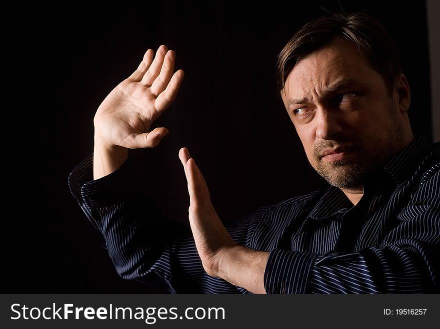 Man in a blue shirt on a black background. Man in a blue shirt on a black background