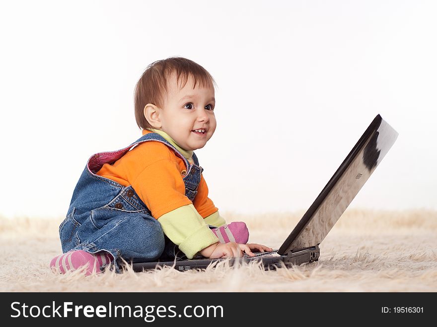 Picture of a baby with laptop on a white. Picture of a baby with laptop on a white