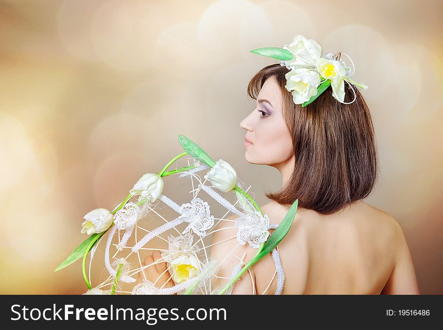 The beautiful girl with a flower on a head and a bouquet