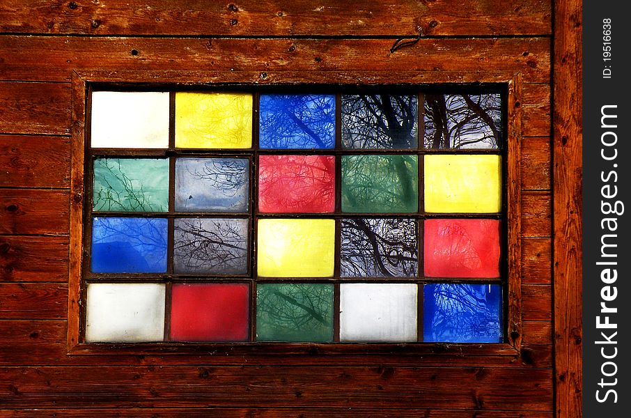 Old stained window in the wooden wall