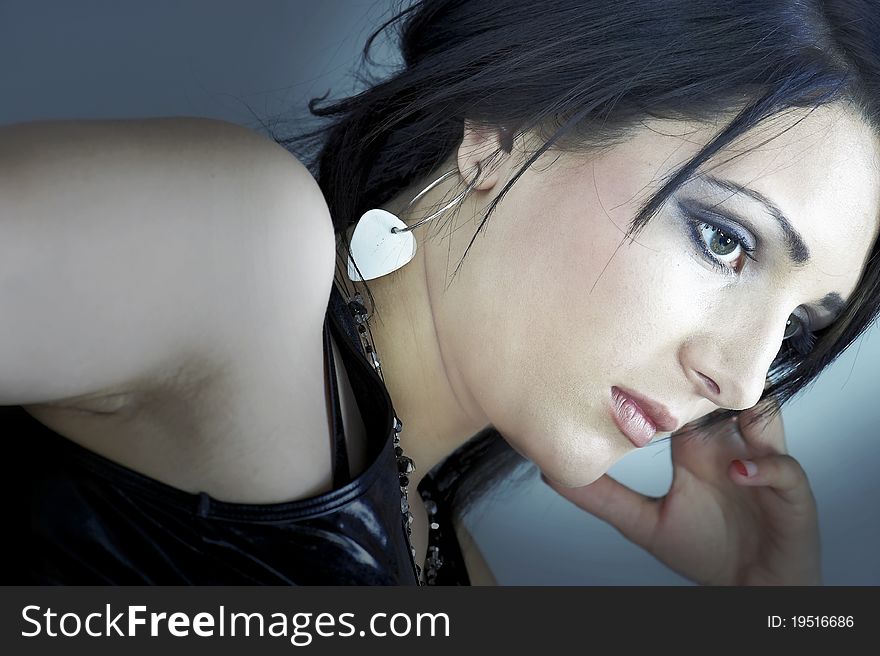 Portrait of beautiful young woman on blue/grey background. Portrait of beautiful young woman on blue/grey background.