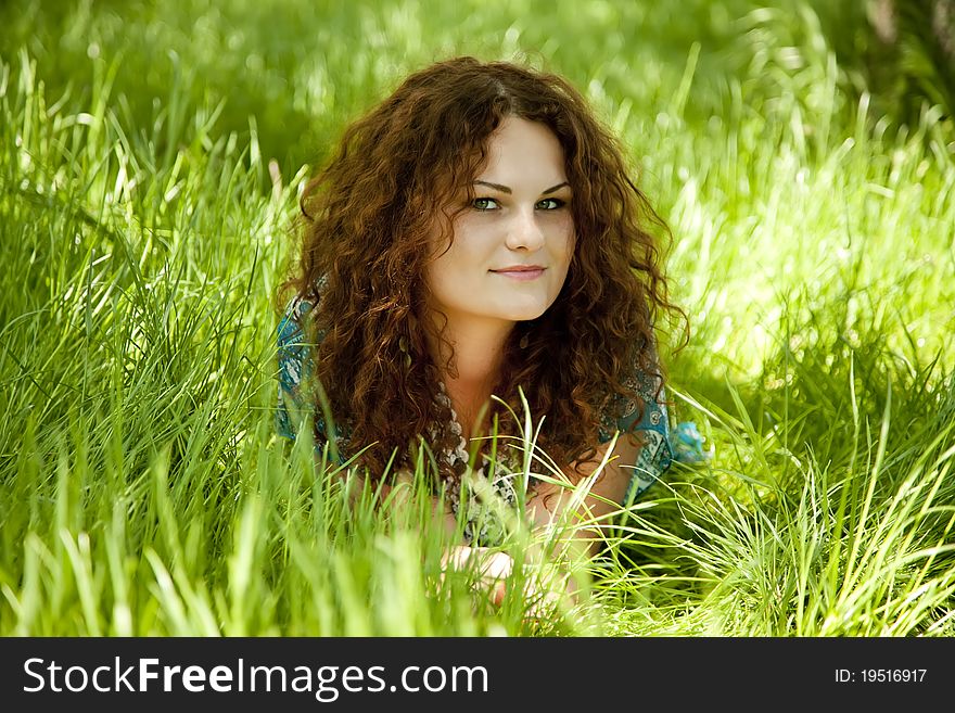 Redhead girl at green grass.