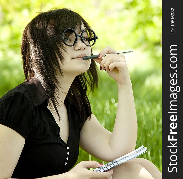 Young teen girl with notebook at green grass