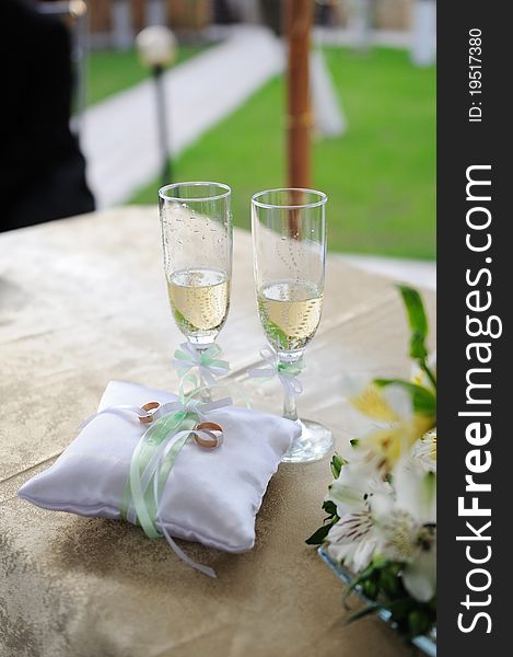 Wedding glasses with champagne and rings on the table. Wedding glasses with champagne and rings on the table