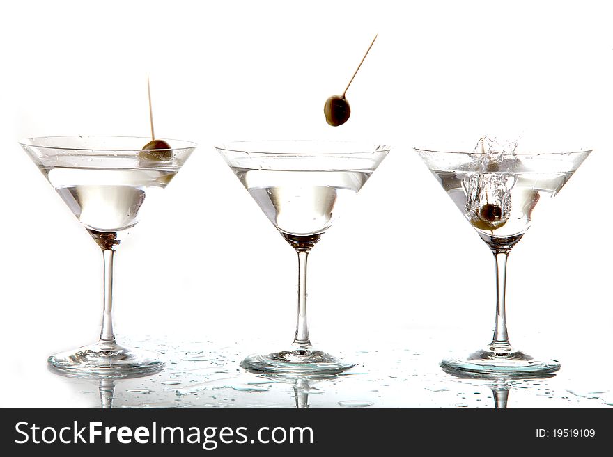 3 cocktail glasses and 3 falling olives. 3 cocktail glasses and 3 falling olives