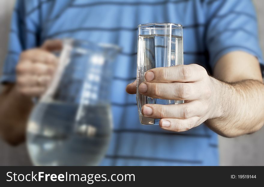 Men's hand giving a glass of fresh water. Men's hand giving a glass of fresh water.