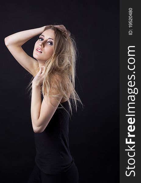 Young beauty blond girl in black dress look at you