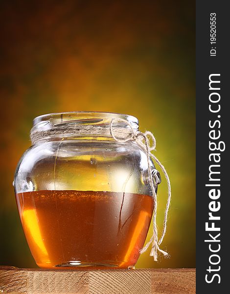 Pot of honey on a wooden table. Pot of honey on a wooden table.