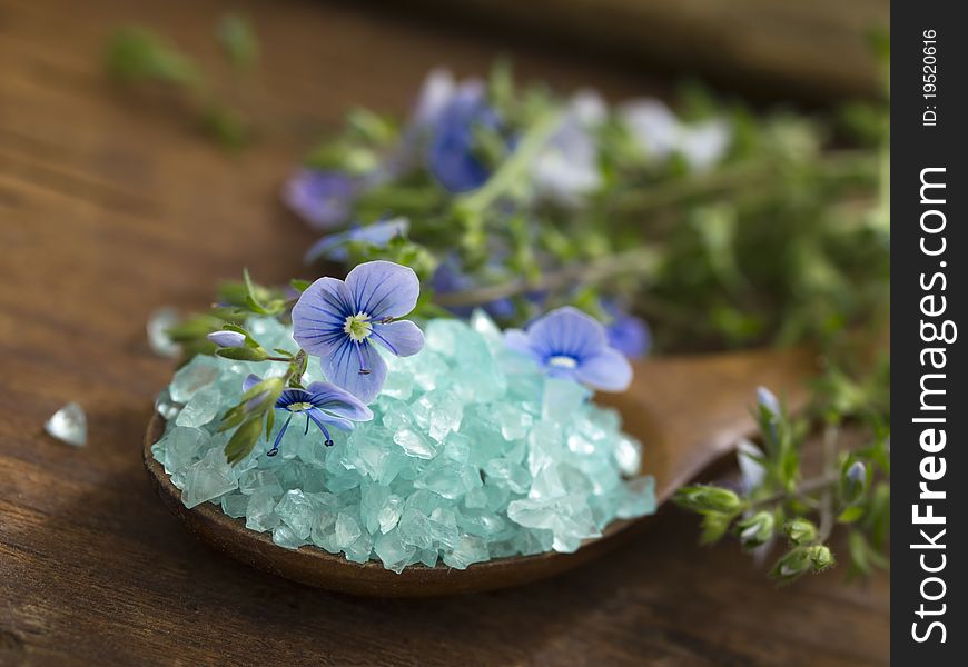 With blue bathing salt over wooden background. With blue bathing salt over wooden background